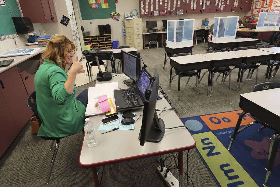 Jeni Larsen, a third grade teacher at Parkview Elementary School in Salt Lake City, gives a thumbs up to her students online on the first day of school in Salt Lake City on Tuesday, Sept. 8, 2020.