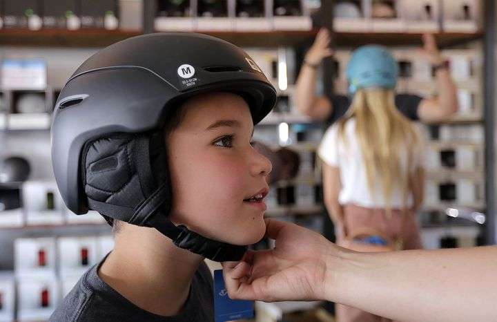 Mac Haynie tries on a helmet at Ski ’N See’s annual sale in the parking lot outside of Ski ’N See in Sandy on Friday, Sept. 4, 2020.