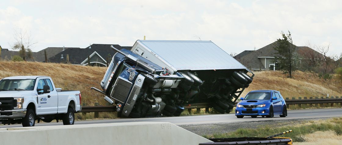 A semitractor-trailer rests on a guardrail after being blown over by high winds on Legacy Highway between Centerville and Farmington on Tuesday, Sept. 8, 2020.