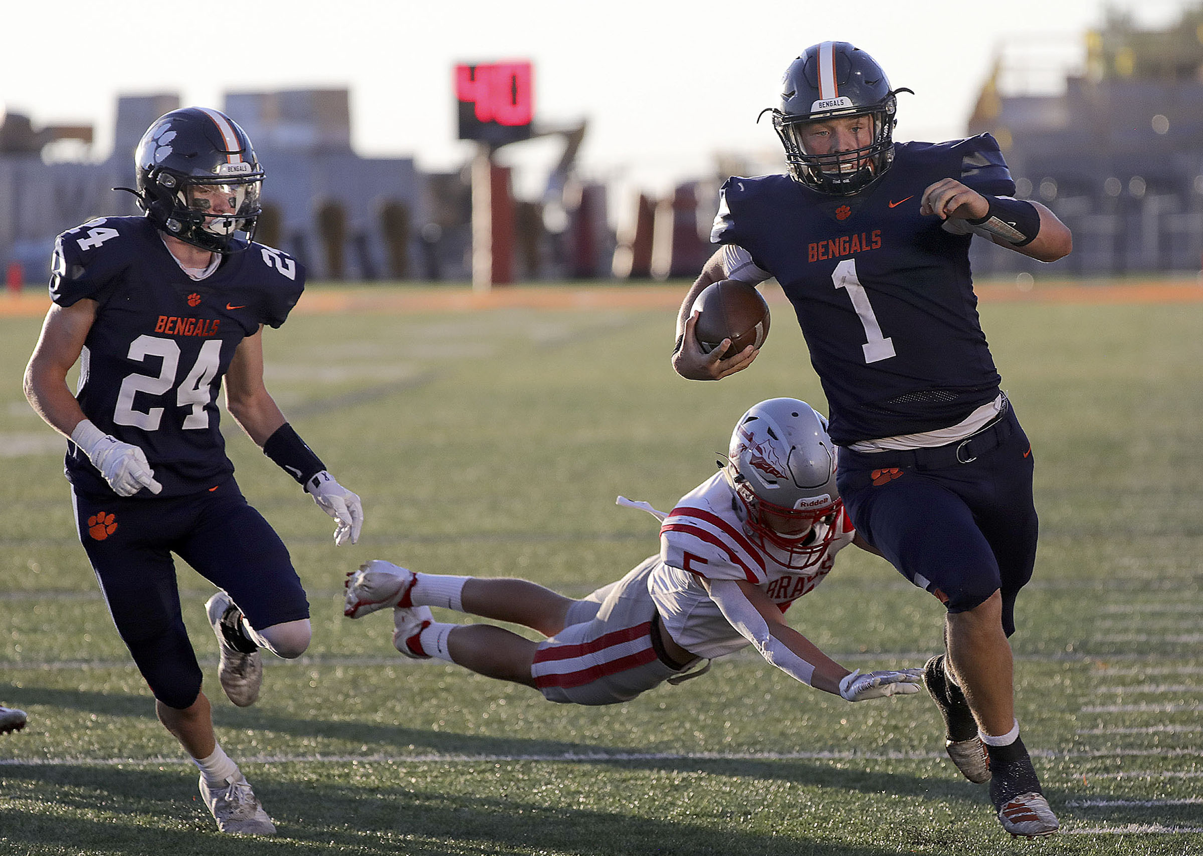 Brighton’s Gabe Curtis (1) runs with the ball past Bountiful’s Payson Hadley (5) during a football game at Brighton High School in Cottonwood Heights on Friday, Sept. 4, 2020. Brighton’s Collin Edwards (24) is on the left.