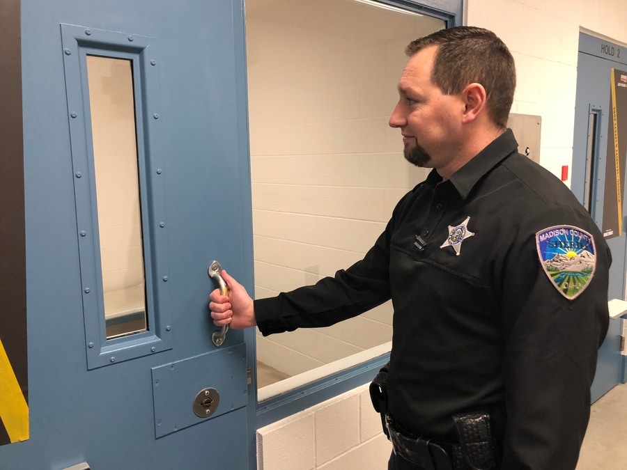 Madison County Jail Lt. Jared Willmore next to a jail cell.