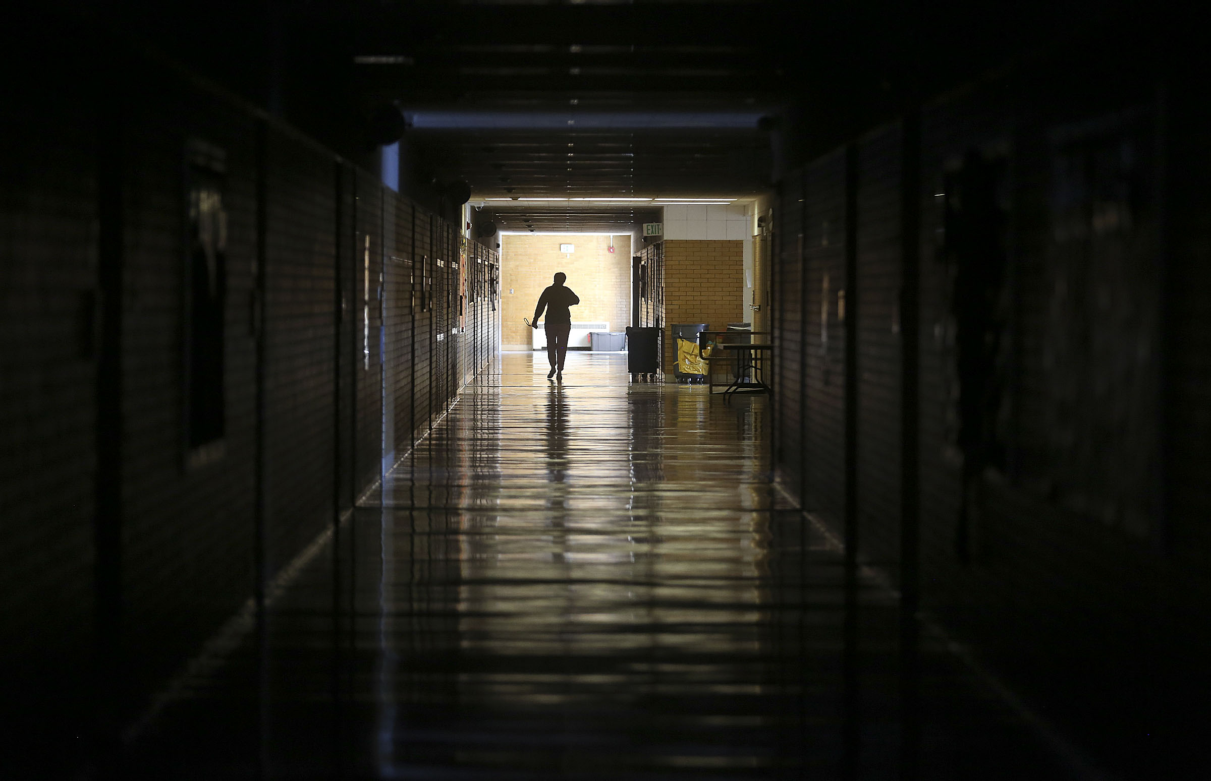 Ali Duff, a third grade teacher who chose to go to work despite classes being canceled, walks through a darkened hallway at Upland Terrace Elementary School in Millcreek on Thursday, Sept. 10, 2020. The school was closed due to a partial power outage.