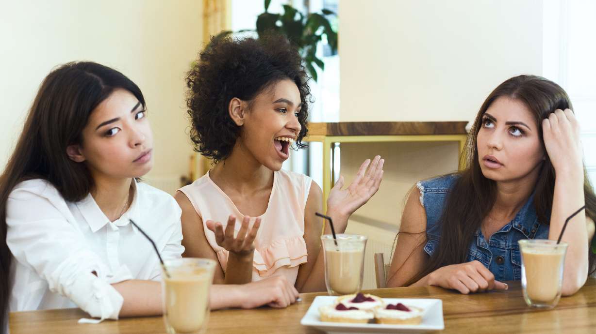 Annoying talkative friend sitting in cafe with girls and storytelling, her friends boring, panorama, empty space, concept