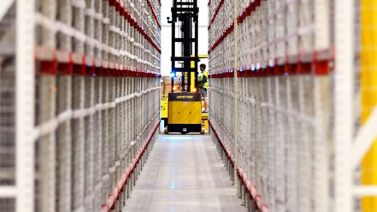 A worker retrieves an item from high up on one of the numerous aisles inside the newly opened Amazon fulfillment center in South Jordan on Monday, Sept. 14, 2020.