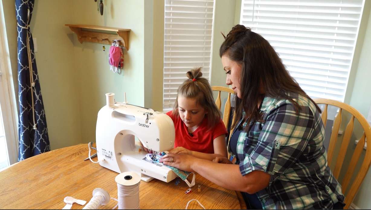 Sterling Lloyd helps her eight-year-old daughter sew a mask with extra soft ear loops.
