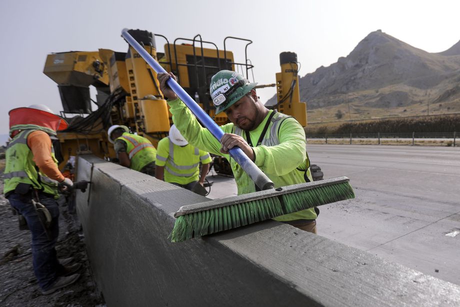 Junior Godinez helps construct a concrete barrier as construction crews work on a new westbound I-80 auxiliary lane between state Route 201 and S.R. 36 in Tooele County on Tuesday, Sept. 15, 2020.