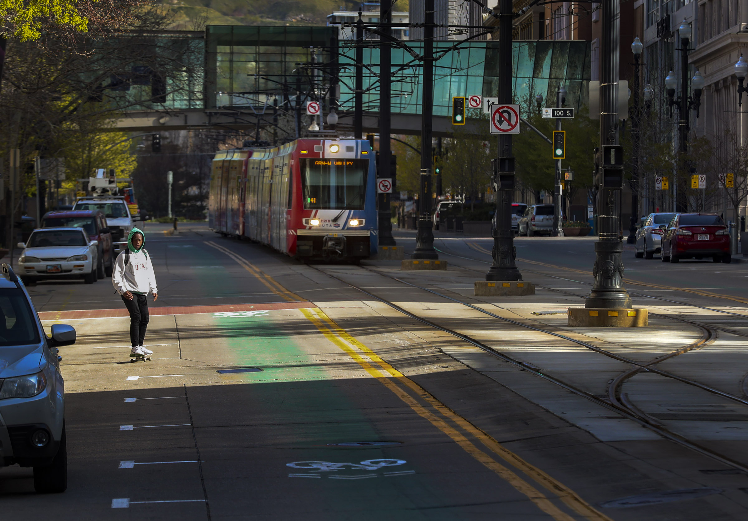 A skateboarder shares empty Main Street with a TRAX train during the morning commute in Salt Lake City on Monday, April 13, 2020. The normally bustling streets were empty due to the COVID-19 pandemic.