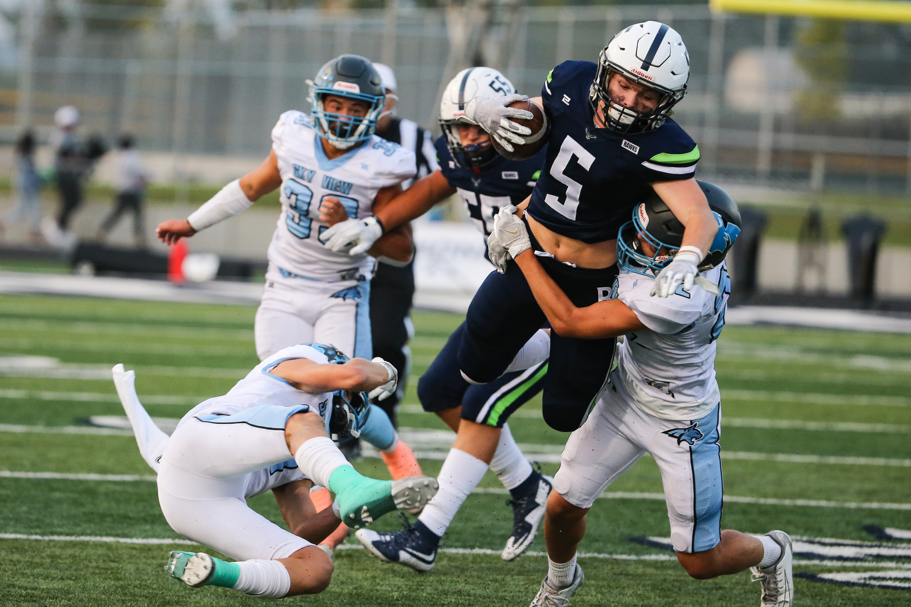 Ridgeline's Evan Webb (5) is brought down by Sky View's Carson Dunkley (22) during a high school football game at Ridgeline High School in Millville on Thursday, Sept. 17, 2020.
