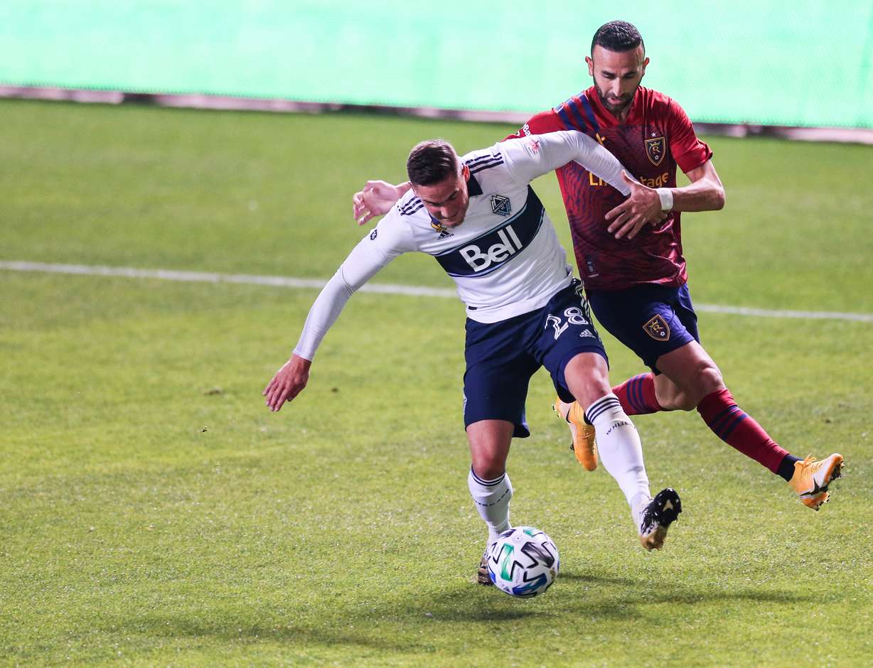Vancouver Whitecaps defender Jake Nerwinski (28) protects the ball against Real Salt Lake forward Justin Meram (9) during an MLS soccer game at Rio Tinto Stadium in Sandy on Saturday, Sept. 19, 2020.