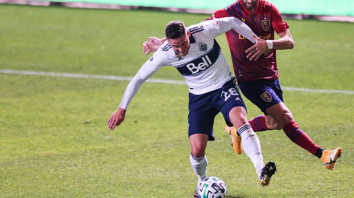 Vancouver Whitecaps defender Jake Nerwinski (28) protects the ball against Real Salt Lake forward Justin Meram (9) during an MLS soccer game at Rio Tinto Stadium in Sandy on Saturday, Sept. 19, 2020.