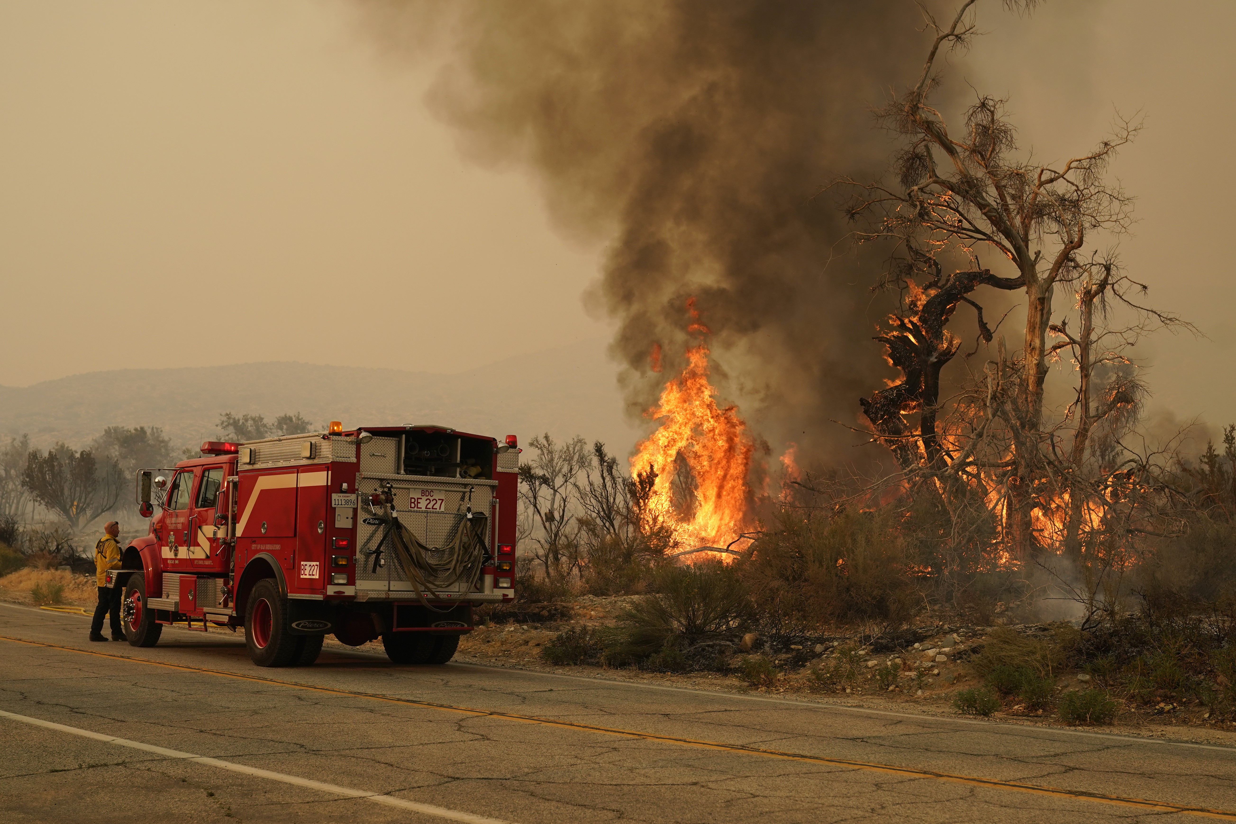 A San Bernardino County Fire Department member keeps an eye on a flareup from the Bobcat Fire on Saturday, Sept. 19, 2020, in Valyermo, Calif.