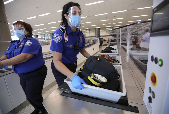 Anna Sosa, supervisory Transportation Security Administration officer, grabs a bin for additional screening at the TSA checkpoint at the new Salt Lake City International Airport on Tuesday, Sept. 22, 2020.
