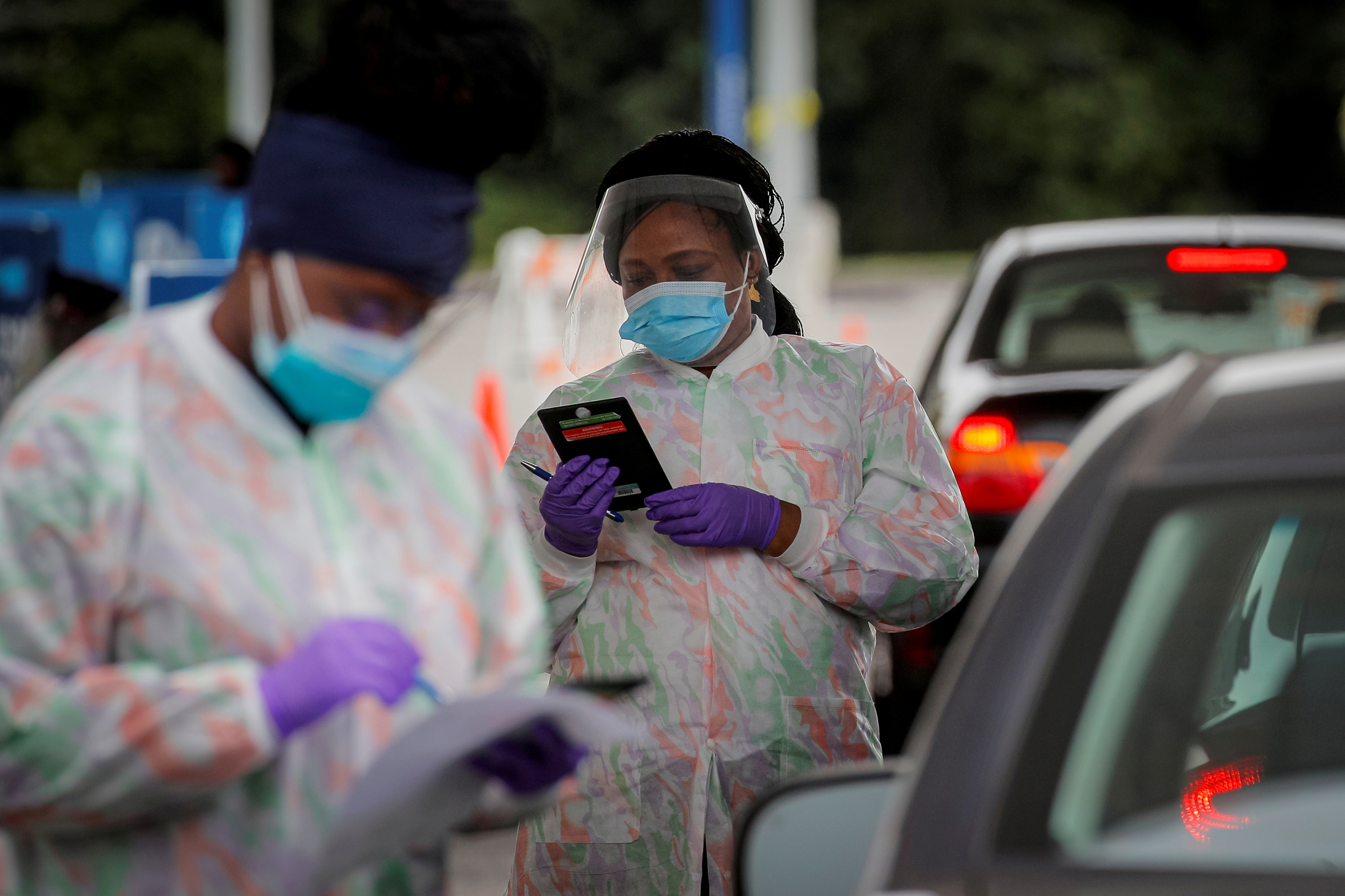 FILE PHOTO: Medical technicians work at a drive-through coronavirus disease (COVID-19) testing facility at the Regeneron Pharmaceuticals company's Westchester campus in Tarrytown, New York, U.S. Sept. 17, 2020. REUTERS/Brendan McDermid