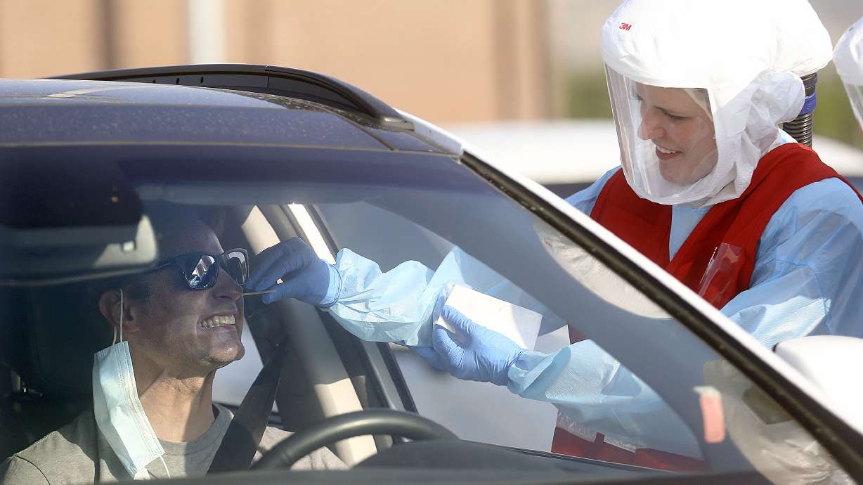Chad Smith reacts as Sara Haight, Salt Lake County Health Department R.N., tests him for COVID-19 outside of Corner Canyon High School in Draper on Monday, Sept. 21, 2020. The Salt Lake County Health Department will be offering COVID-19 testing at Corner Canyon High School again on Monday, Sept. 28, from 4 p.m. to 7 p.m.