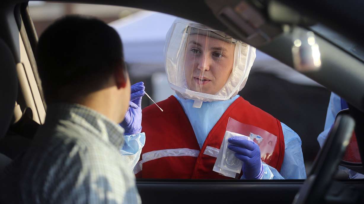 Maya Rockwell talks to Adam Hunter before testing him for COVID-19 outside of Corner Canyon High School in Draper on Monday, Sept. 21, 2020. The Salt Lake County Health Department will be offering COVID-19 testing at Corner Canyon High School again on Monday, Sept. 28, from 4 p.m. to 7 p.m.
