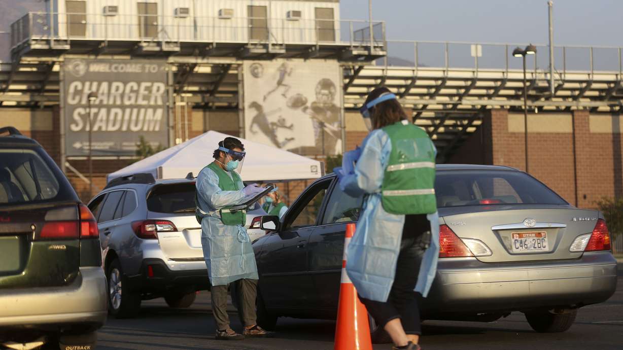 Chase Schumaker, Salt Lake County Health Department mobile testing team administrator, collects information from those lining up to get COVID-19 tests outside of Corner Canyon High School in Draper on Monday, Sept. 21, 2020. The Salt Lake County Health Department will be offering COVID-19 testing at Corner Canyon High School again on Monday, Sept. 28, from 4 p.m. to 7 p.m.