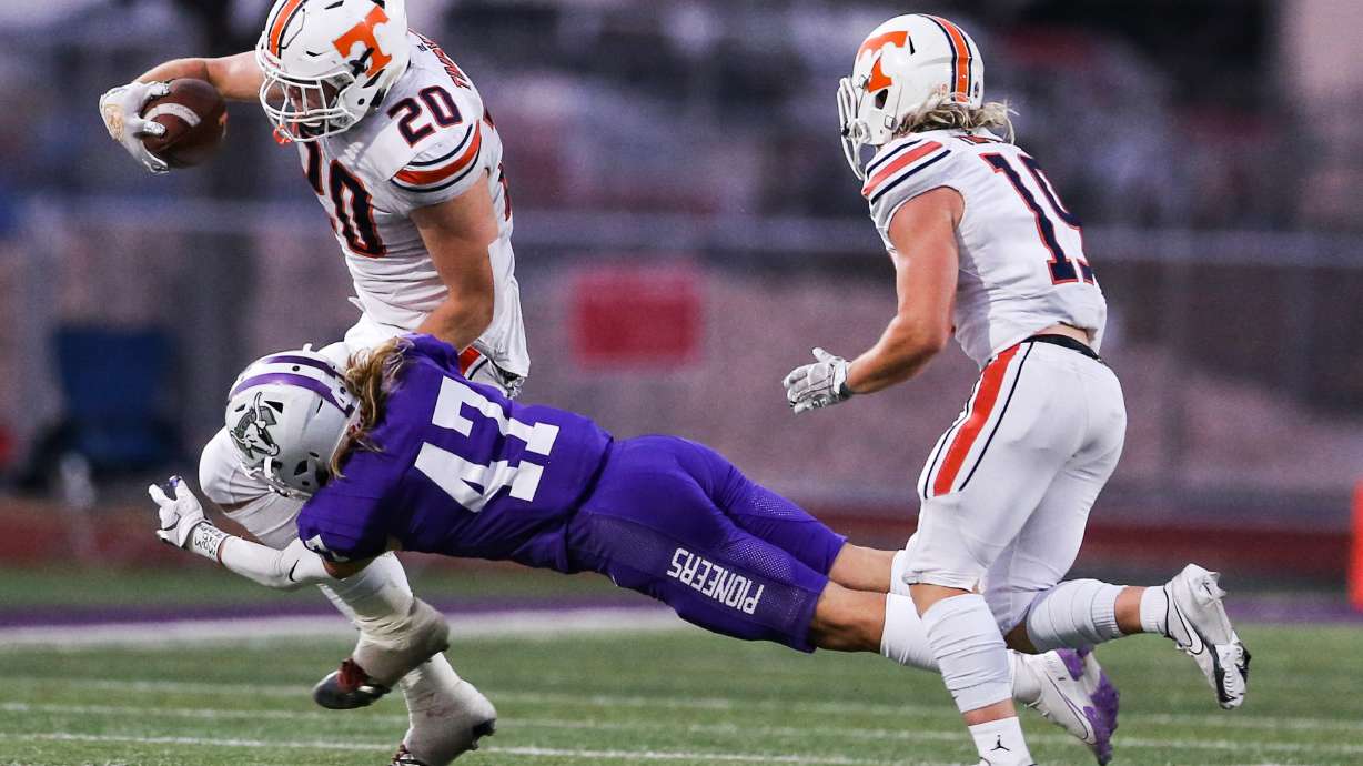 Timpview's Carsen Ryan (20) carries the ball against the Lehi defense during a high school football game at Lehi High School in Lehi on Friday, Sept. 25, 2020.