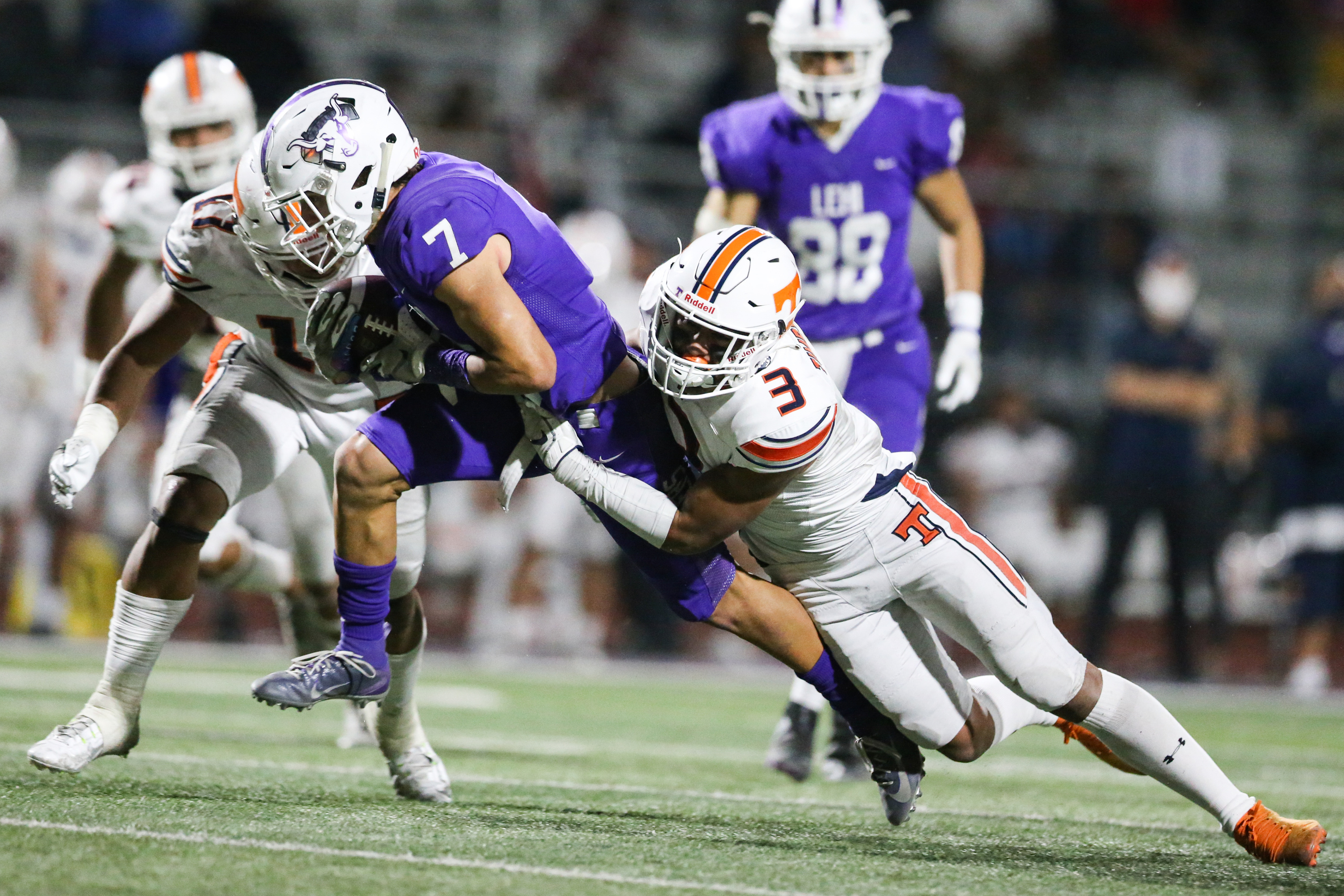 Lehi’s Grady Gonzalez (7) carries the ball for a first down against Timpview’s Raider Damuni (3) during a high school football game at Lehi High School in Lehi on Friday, Sept. 25, 2020.