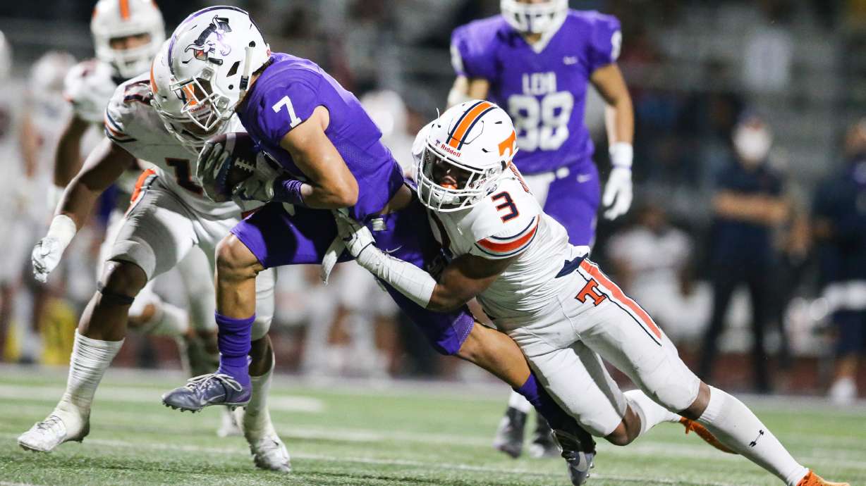 Lehi’s Grady Gonzalez (7) carries the ball for a first down against Timpview’s Raider Damuni (3) during a high school football game at Lehi High School in Lehi on Friday, Sept. 25, 2020.