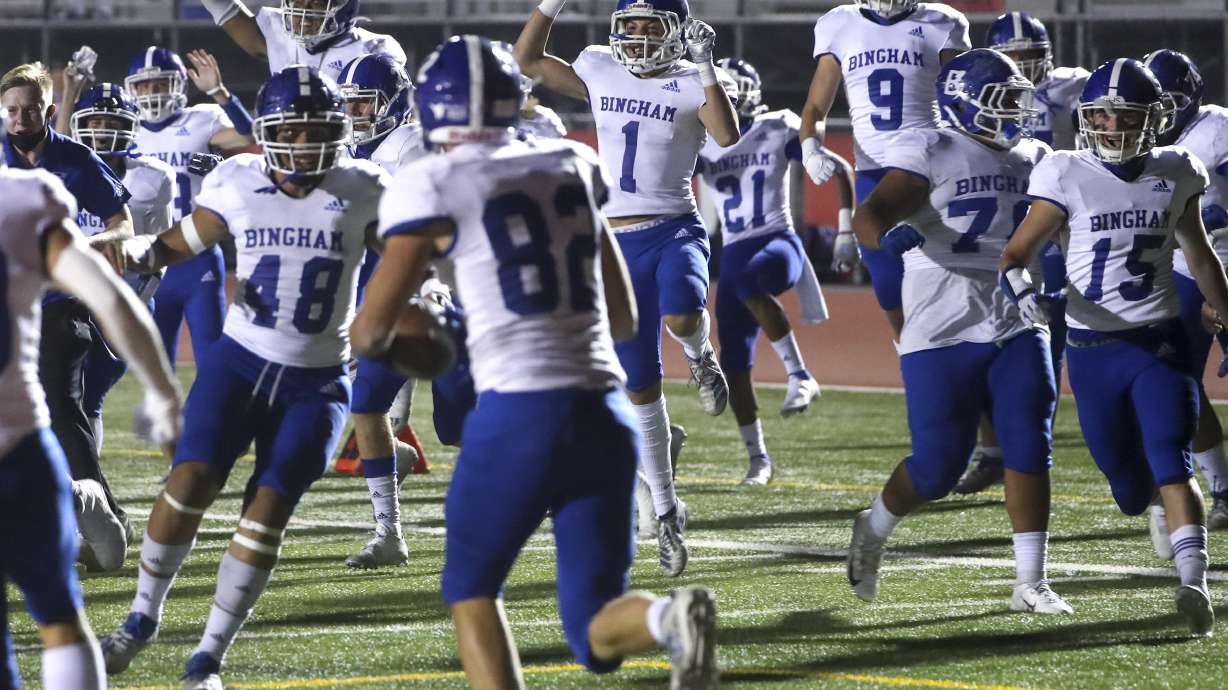 The Bingham bench explodes onto the field after Joshua Woolf (82), center, caught a pass in the end zone for a two-point conversion, giving the Miners an overtime victory over the Leopards at East High School in Salt Lake City on Friday, Sept. 25, 2020.