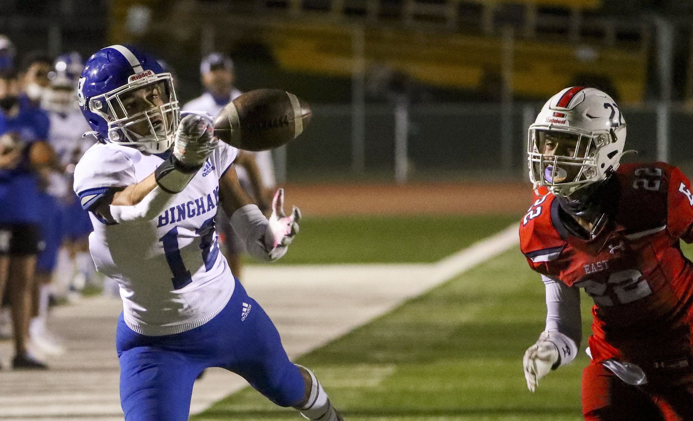 Bingham's Isaiah Glasker stretches for the ball in front of East's Mapa Vaenuku during game at East High School in Salt Lake City on Friday, Sept. 25, 2020.
