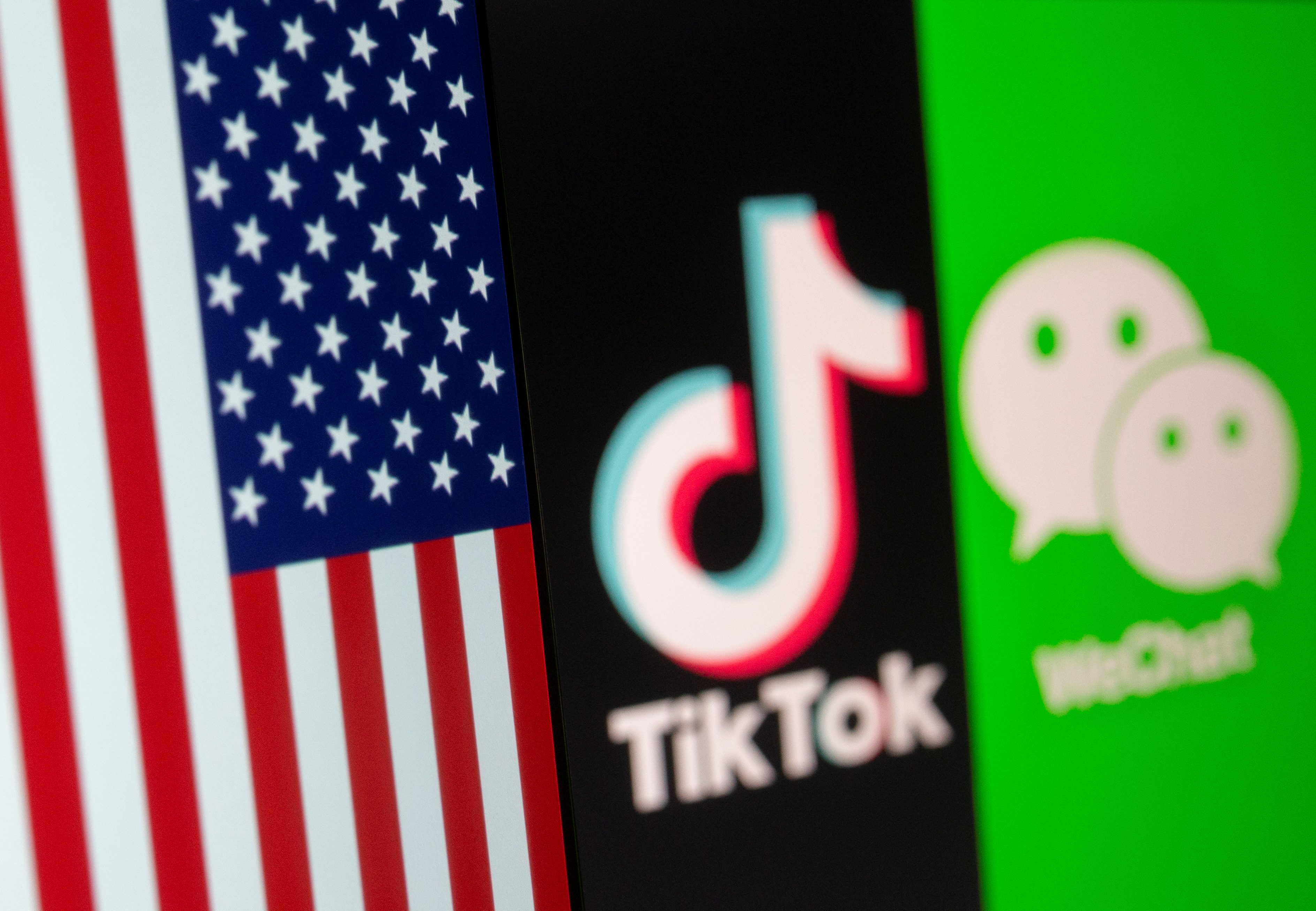 FILE PHOTO: A U.S. flag is seen on a smartphone in front of displayed Tik Tok and WeChat logos in this illustration taken September 18, 2020. REUTERS/Dado Ruvic/Illustration