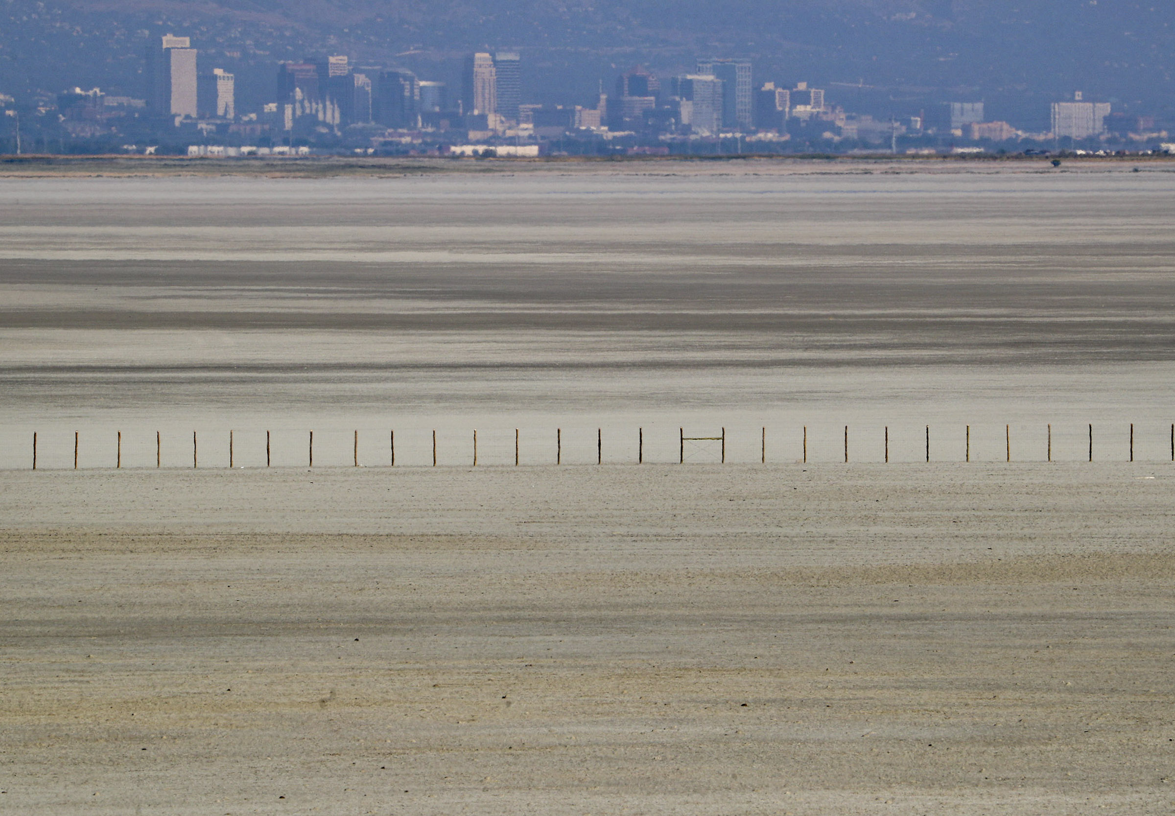 The Salt Lake City skyline rises above a receding Great Salt Lake as pictured from Antelope Island on Aug. 25, 2020.