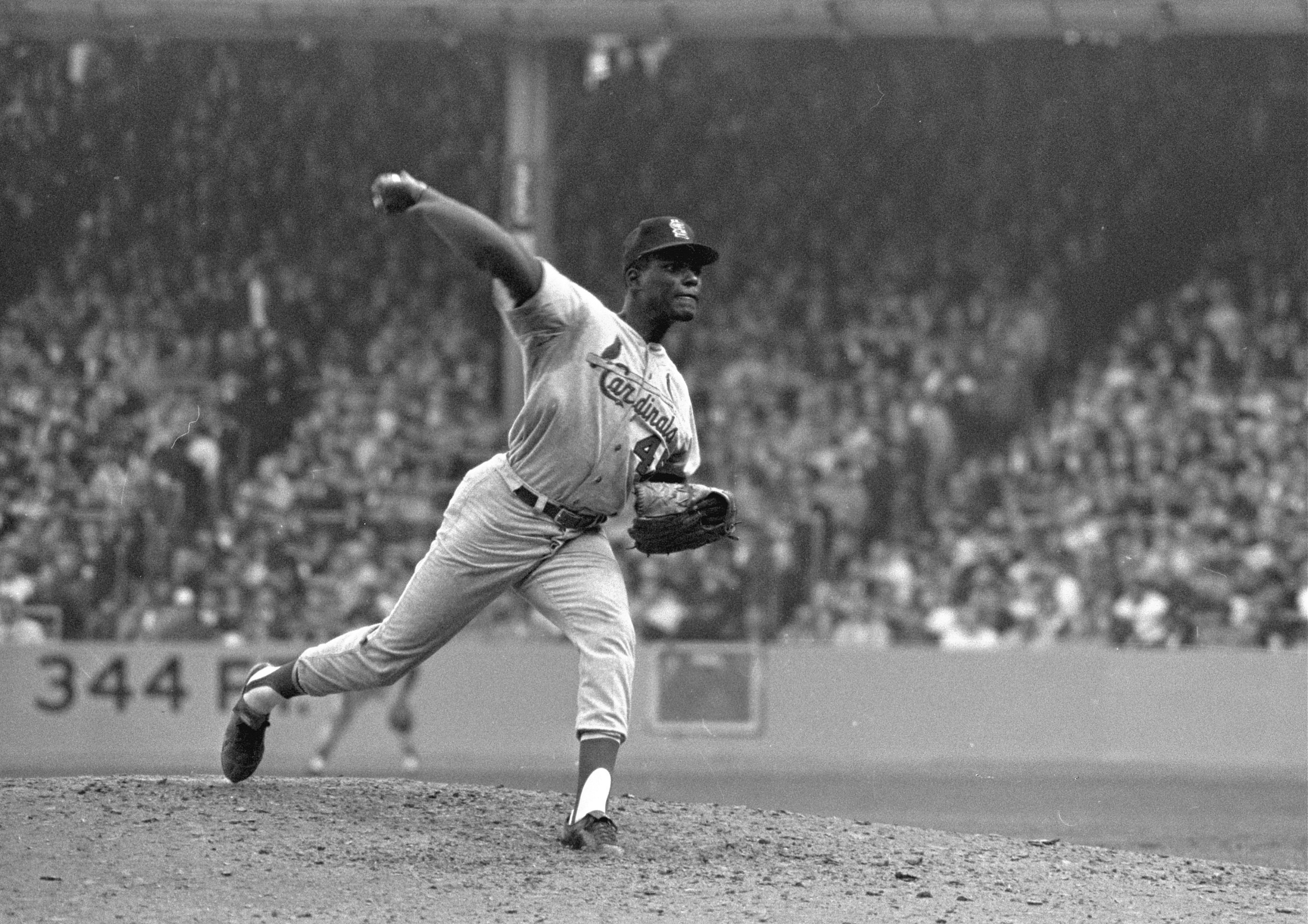 FILE - In this Oct. 12, 1964, file photo, St. Louis Cardinals pitcher Bob Gibson throws to a New York Yankees batter during Game 5 of the World Series, in New York. Gibson went all the way for a 5-2 win. Gibson, the dominating pitcher who won a record seven consecutive World Series starts and set a modern standard for excellence when he finished the 1968 season with a 1.12 ERA, died Friday, Oct. 2, 2020. He was 84.