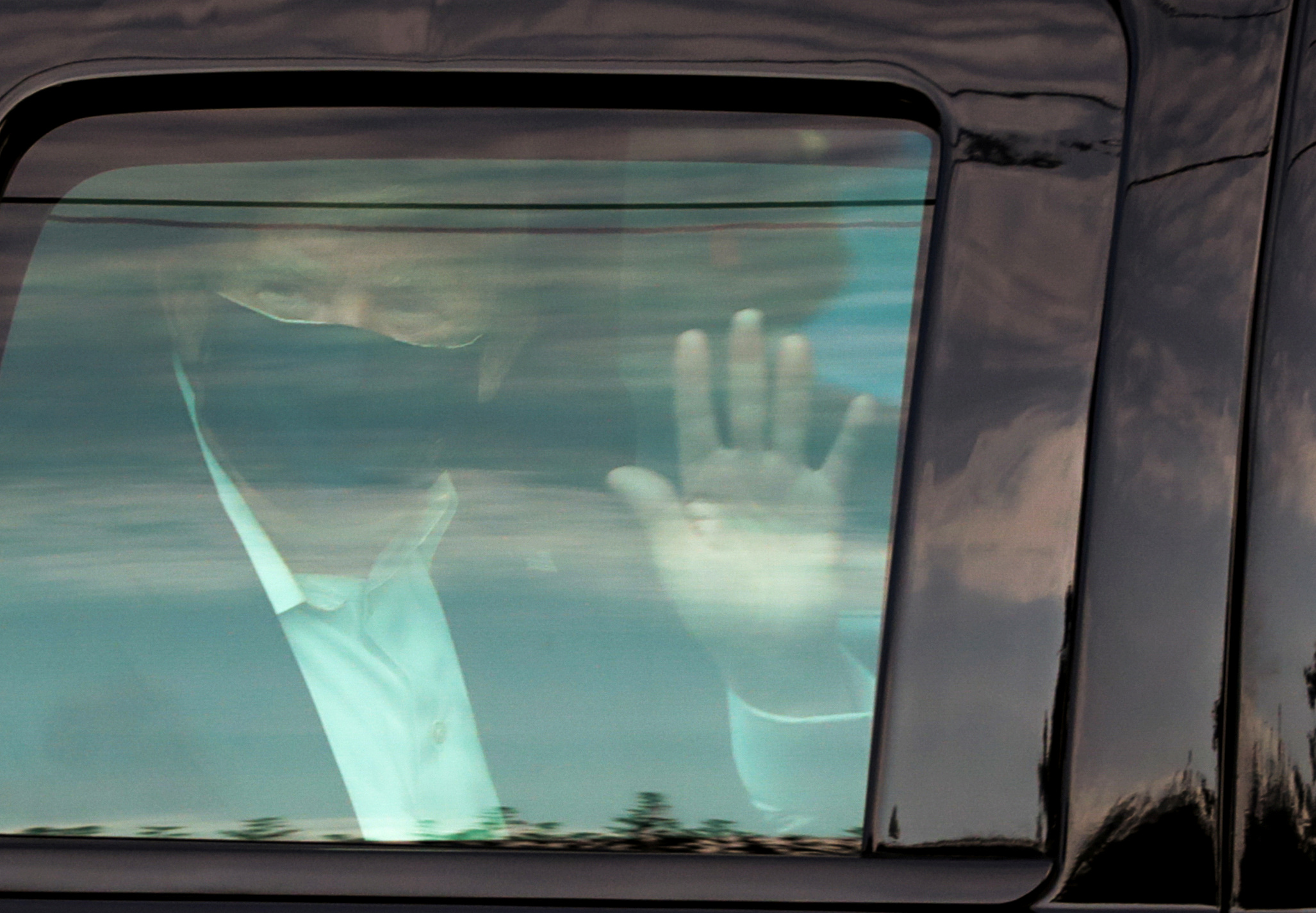 U.S. President Donald Trump waves to supporters as he briefly rides by in the presidential motorcade in front of Walter Reed National Military Medical Center, where he is being treated for coronavirus disease (COVID-19) in Bethesda, Maryland, U.S. October 4, 2020.