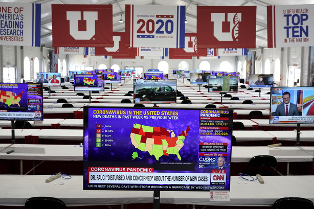 A television broadcasts news on the coronavirus pandemic as preparations take place for the vice presidential debate in a press filing center at the University of Utah, Monday, Oct. 5, 2020, in Salt Lake City. The vice presidential debate between Vice President Mike Pence and Democratic vice presidential candidate, Sen. Kamala Harris, D-Calif., is scheduled for Oct. 7.