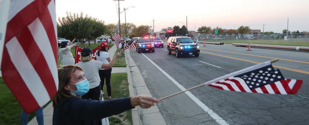 Supporters wave as Vice President Mike Pence's motorcade moves toward I-215 as he arrives in Salt Lake City on Monday, Oct. 5, 2020.