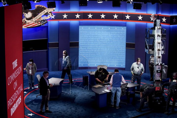 Crew members put the final touches on the stage, which now includes plexiglass partitions, at Kingsbury Hall at the University of Utah in Salt Lake City on Tuesday, Oct. 6, 2020, in preparation for Wednesday’s vice presidential debate.