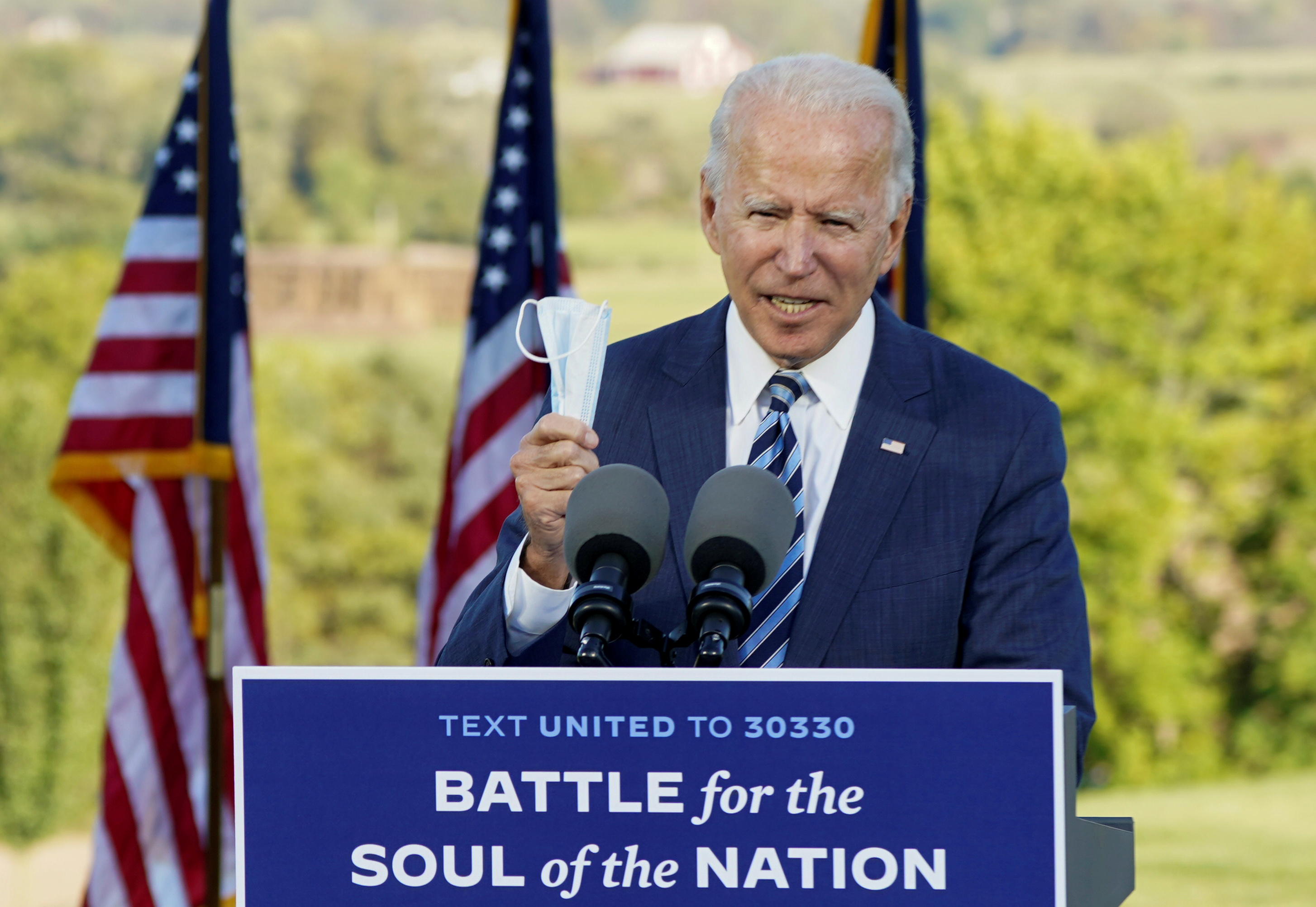 FILE PHOTO: Democratic U.S. presidential nominee Joe Biden holds up his face mask while speaking during a campaign stop in Gettysburg, Pennsylvania, U.S., Oct. 6, 2020.