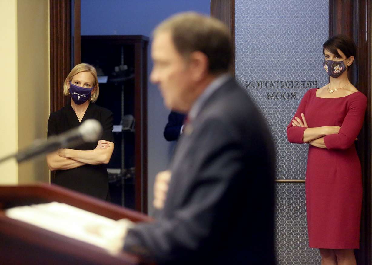 Dr. Emily Spivak, associate professor of infectious disease at University of Utah Health, left, and state epidemiologist Dr. Angela Dunn, right, listen as Gov. Gary Herbert speaks during a COVID-19 press conference at the Capitol in Salt Lake City on Thursday, Oct. 8, 2020.