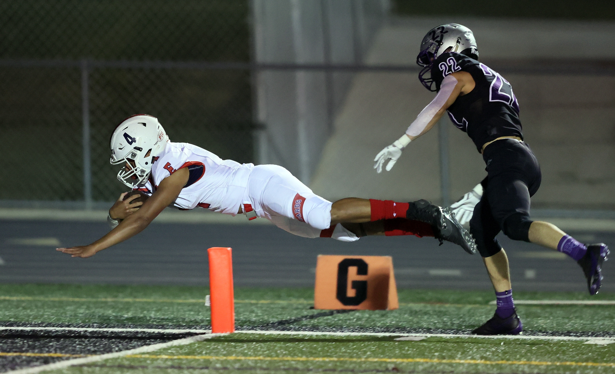 East's Siona Vailahi dives into the end zone for a score with Riverton's Colin Hauge chasing from behind as East and Riverton play football at Riverton on Friday, Oct. 9, 2020. East won 36-20.