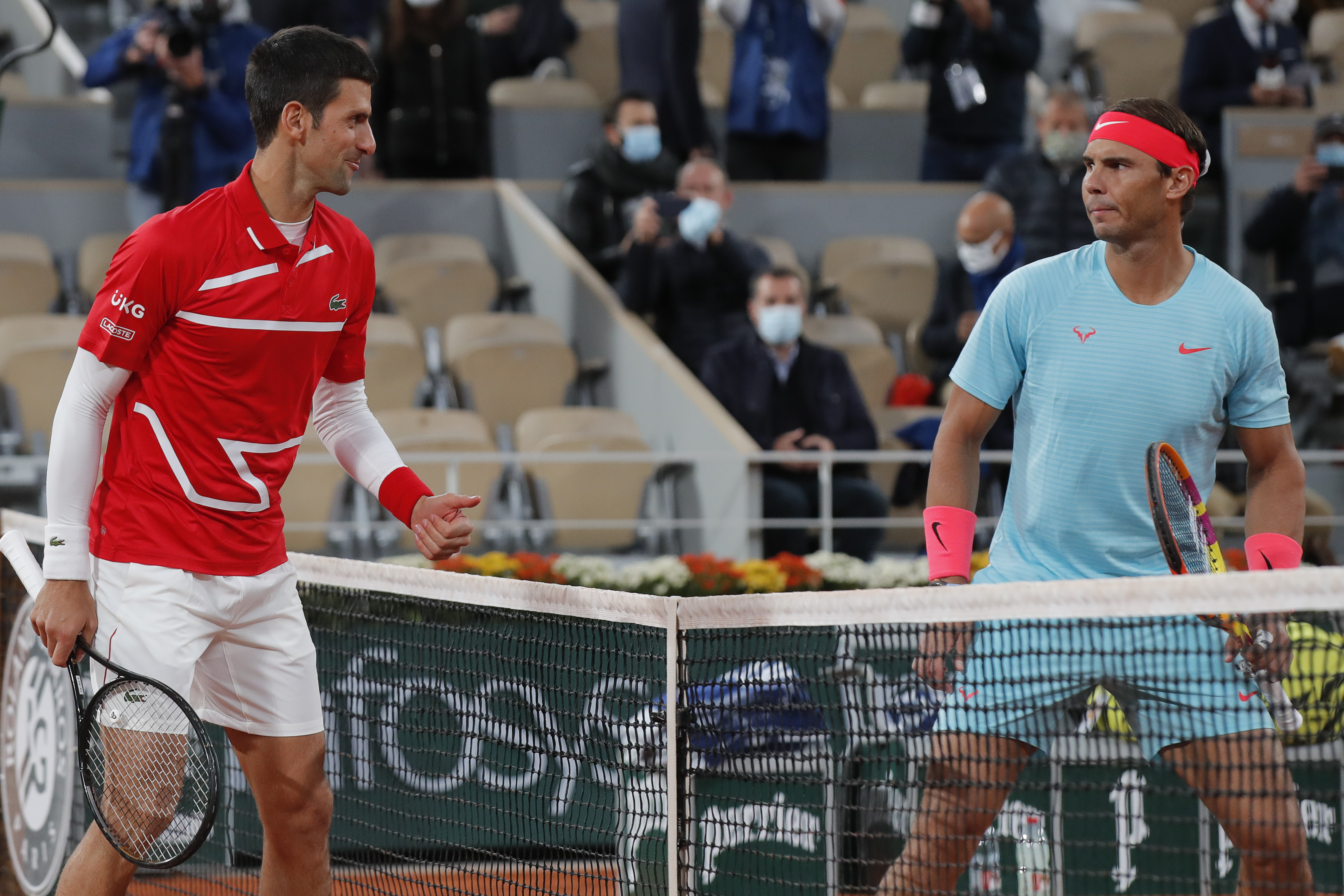 Serbia's Novak Djokovic, left, and Spain's Rafael Nadal look at each other as they pose for images prior to the final match of the French Open tennis tournament at the Roland Garros stadium in Paris, France, Sunday, Oct. 11, 2020.