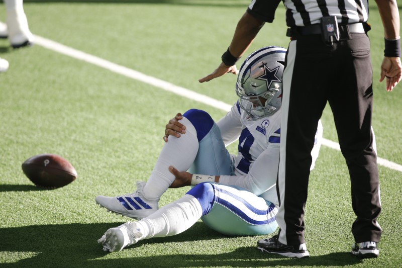 Oct 11, 2020; Arlington, Texas, USA; Dallas Cowboys quarterback Dak Prescott (4) holds his leg after an injury in the third quarter against the New York Giants at AT&T Stadium. Mandatory Credit: Tim Heitman-USA TODAY Sports