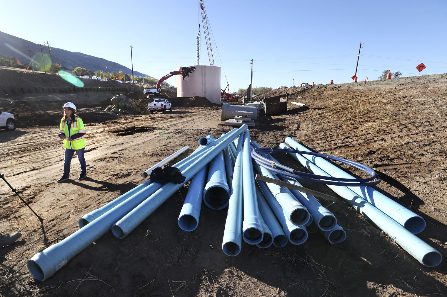 Layton Mayor Joy Petro talks about the city’s old water tank as crews with the Utah Department of Transportation begin dismantling it, pictured behind, near the intersection of Oak Hills Drive and U.S. 89 on Monday, Oct. 12, 2020. The city recently constructed a new water tank that is now in operation, and the old one is being removed to accommodate construction on the U.S. 89 widening project.