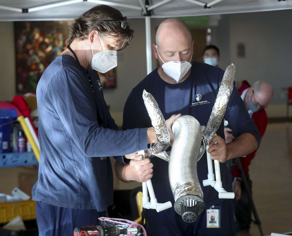 Hospital staff members Gary Carvey and Matt Lowell work on decorating Skylar Skuza’s wheelchair in a Power Ranger theme during the hospital’s annual wheelchair costume clinic at Shriners Hospitals for Children in Salt Lake City on Thursday, Oct. 15, 2020.