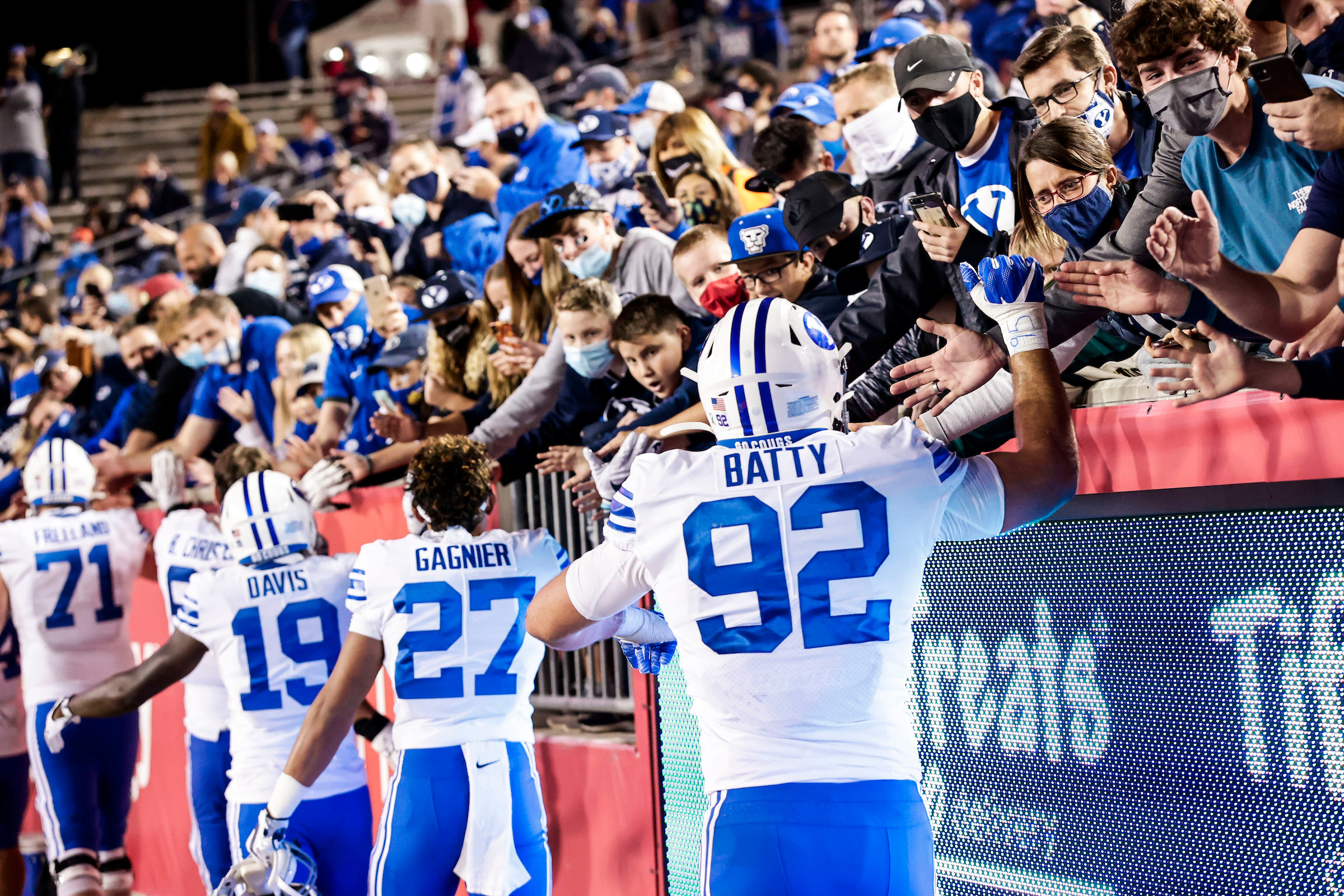 BYU's Tyler Batty, Tevita Gagnier and Miles Davis celebrate with fans after a 43-26 win over Houston, Friday, Oct. 16, 2020 at TDECU Stadium in Houston, Texas. Batty and longsnapper Austin Riggs signed NIL endorsements this week with Balmshot, a family-owned business based in Riggs' hometown of Eagle, Idaho. 