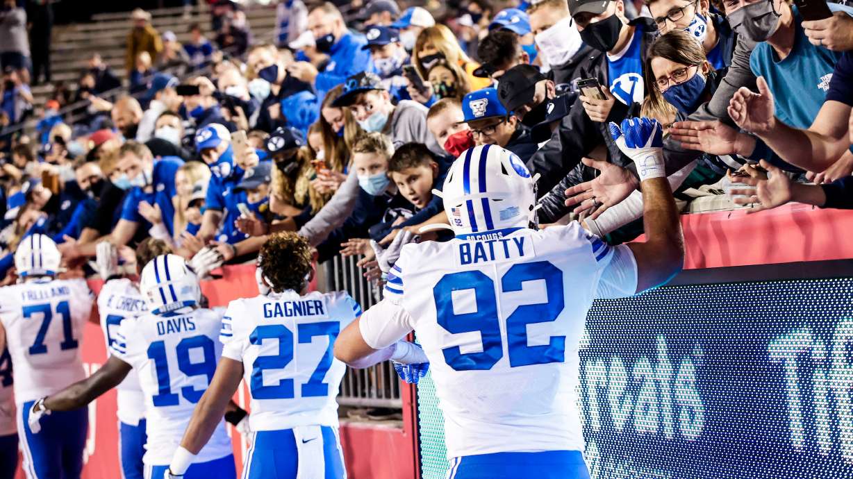 BYU's Tyler Batty, Tevita Gagnier and Miles Davis celebrate with fans after a 43-26 win over Houston, Friday, Oct. 16, 2020 at TDECU Stadium in Houston, Texas. Batty and longsnapper Austin Riggs signed NIL endorsements this week with Balmshot, a family-owned business based in Riggs' hometown of Eagle, Idaho.