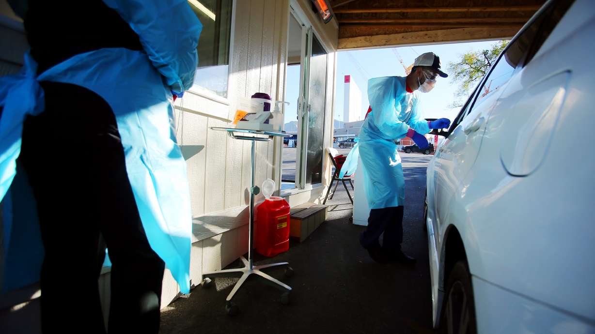 Nurses Polly Crookston and Daniel Salas Jimenez work at a new COVID-19 testing site in the parking lot of Rice-Eccles Stadium in Salt Lake City on Monday, Oct. 12, 2020. The testing site is open Monday through Friday, 8 a.m. to 4 p.m., and Saturday and Sunday, 8 a.m. to noon. Appointments are required.