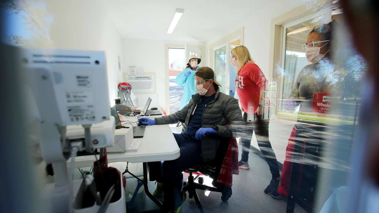 Health care workers process patients at a new COVID-19 testing site in the parking lot of Rice-Eccles Stadium in Salt Lake City on Monday, Oct. 12, 2020. The testing site is open Monday through Friday, 8 a.m. to 4 p.m., and Saturday and Sunday, 8 a.m. to noon. Appointments are required.
