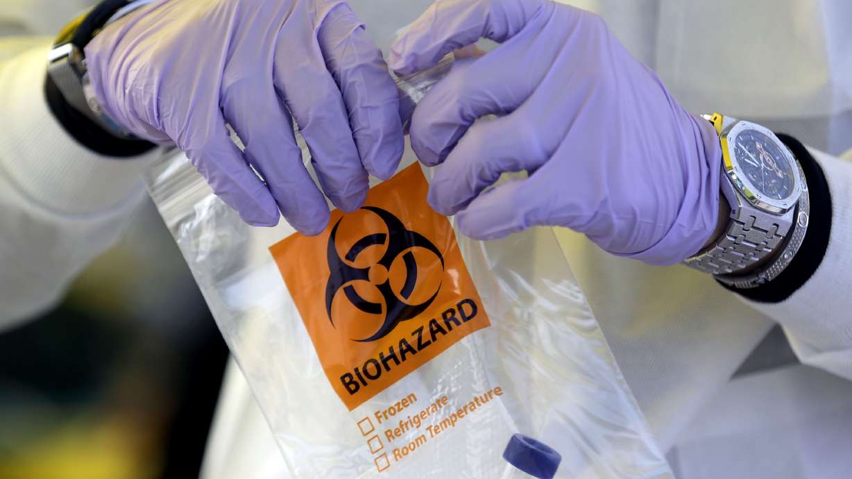 Phlebotomist David Sagae handles a vial of saliva at an Intermountain Healthcare COVID-19 mobile testing site outside of Orem Community Hospital in Orem on Tuesday, Oct. 6, 2020.