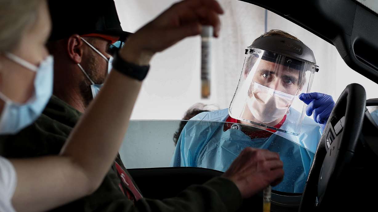 Liz and Sam Rodgers verify their COVID-19 saliva tests to Josh Anderson at a drive-thru test site at University of Utah Health's South Jordan Health Center in South Jordan on Friday, Oct. 2, 2020.