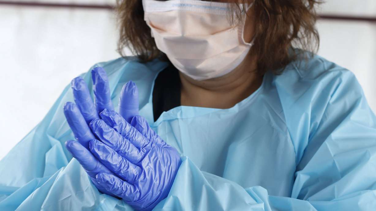 Medical assistant Guillianna Lint sanitizes her hands in between patients at a COVID-19 test site at University of Utah Health's South Jordan Health Center in South Jordan on Friday, Oct. 2, 2020.