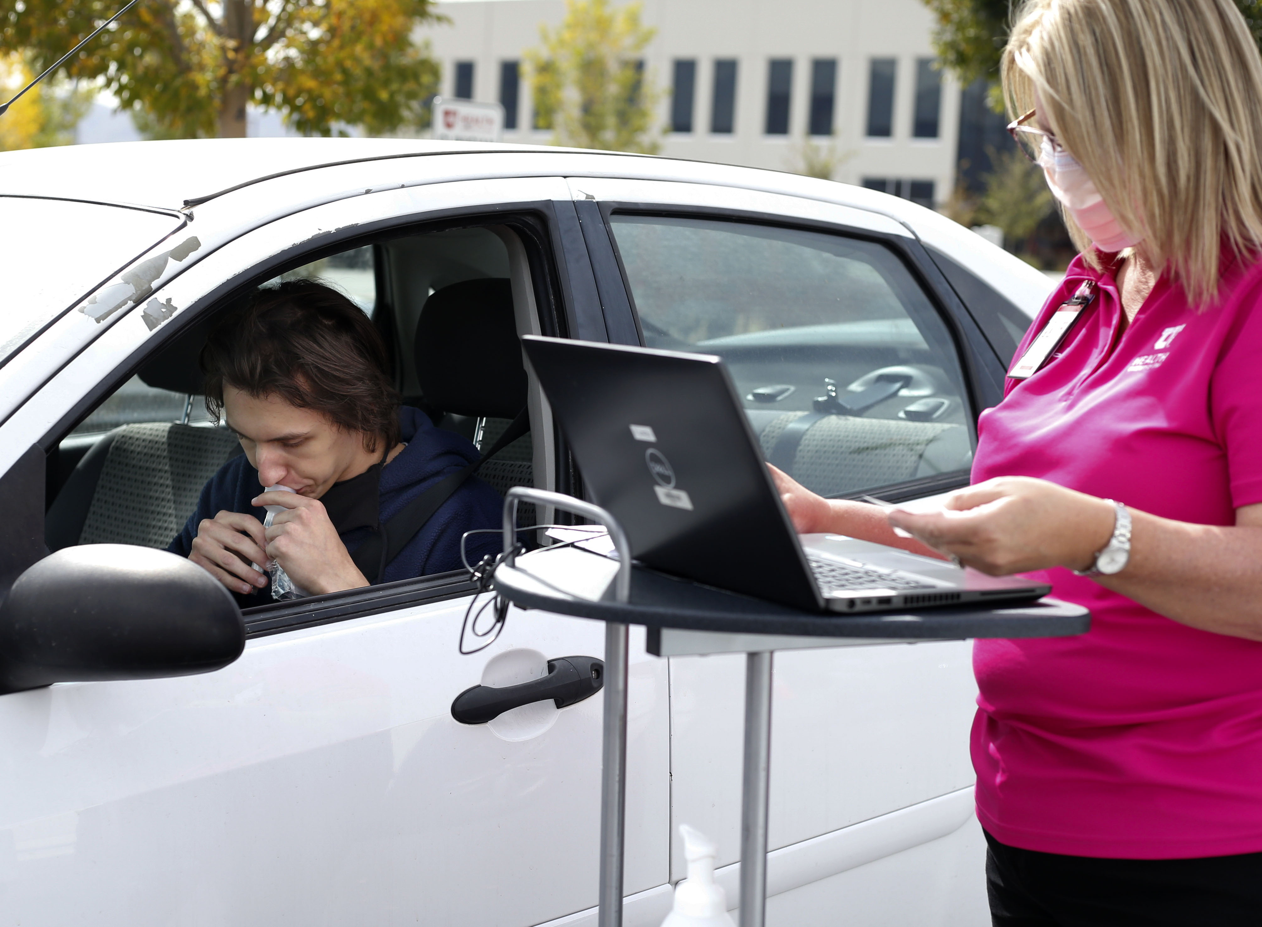 Sven Karabegovic spits into a COVID-19 saliva test at a drive-thru test site at University of Utah Health's South Jordan Health Center in South Jordan on Friday, Oct. 2, 2020.