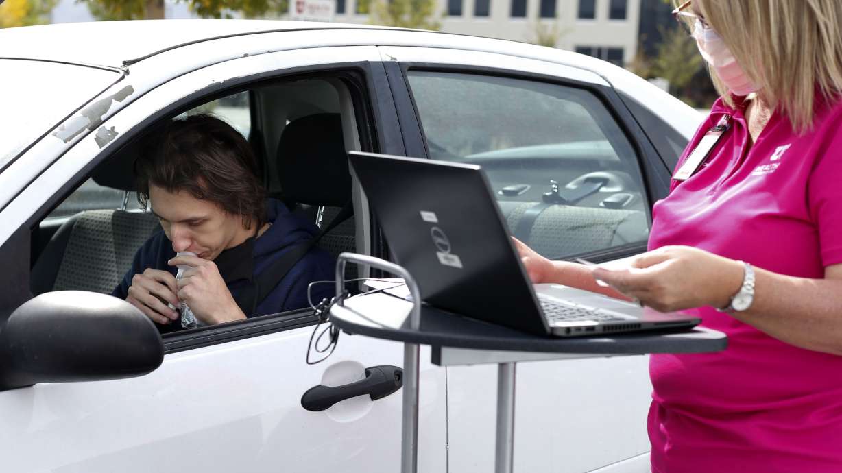 Sven Karabegovic spits into a COVID-19 saliva test at a drive-thru test site at University of Utah Health's South Jordan Health Center in South Jordan on Friday, Oct. 2, 2020.