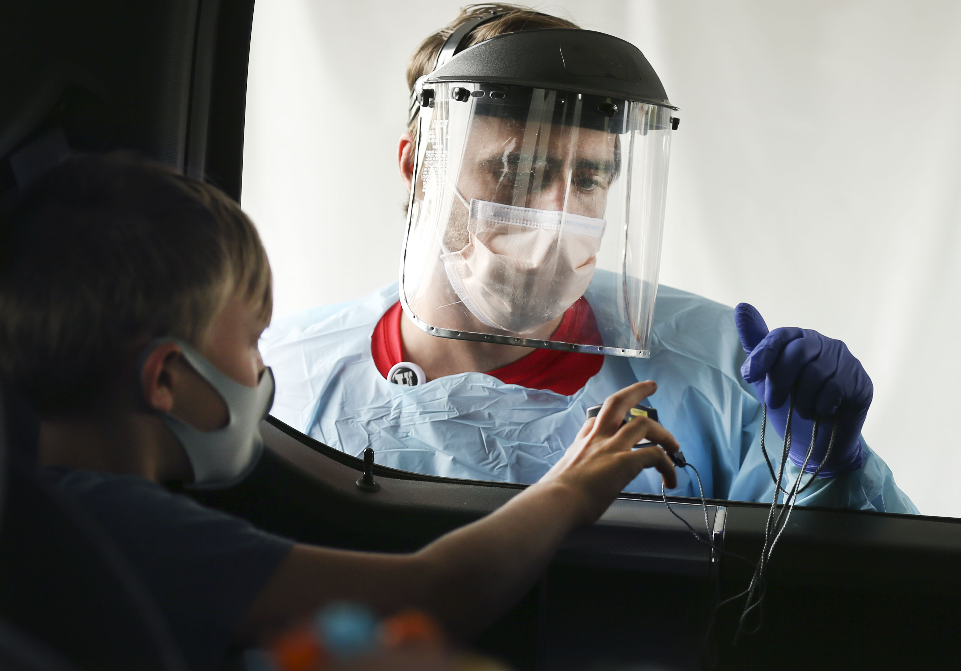 Josh Anderson checks Max Rodgersâ?? vital signs at a drive-thru COVID-19 test site at University of Utah Health's South Jordan Health Center in South Jordan on Friday, Oct. 2, 2020.