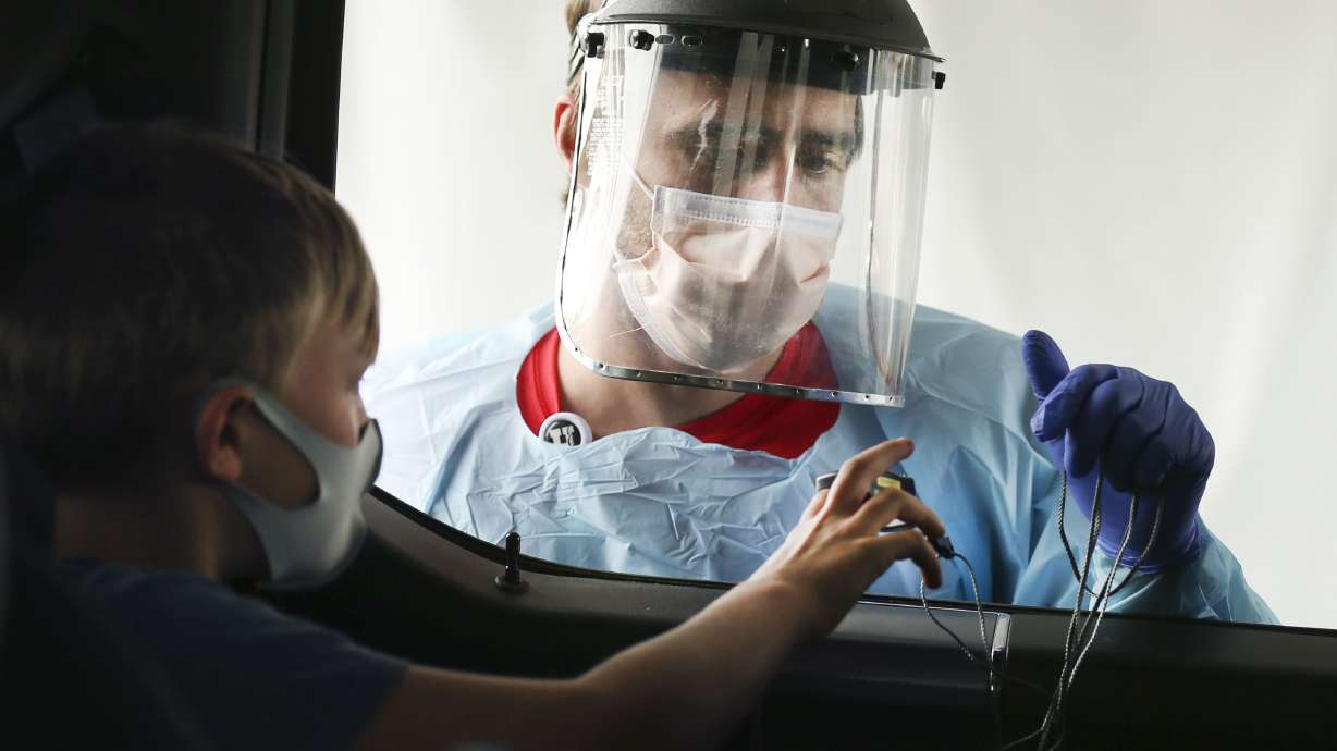 Josh Anderson checks Max Rodgersâ?? vital signs at a drive-thru COVID-19 test site at University of Utah Health's South Jordan Health Center in South Jordan on Friday, Oct. 2, 2020.